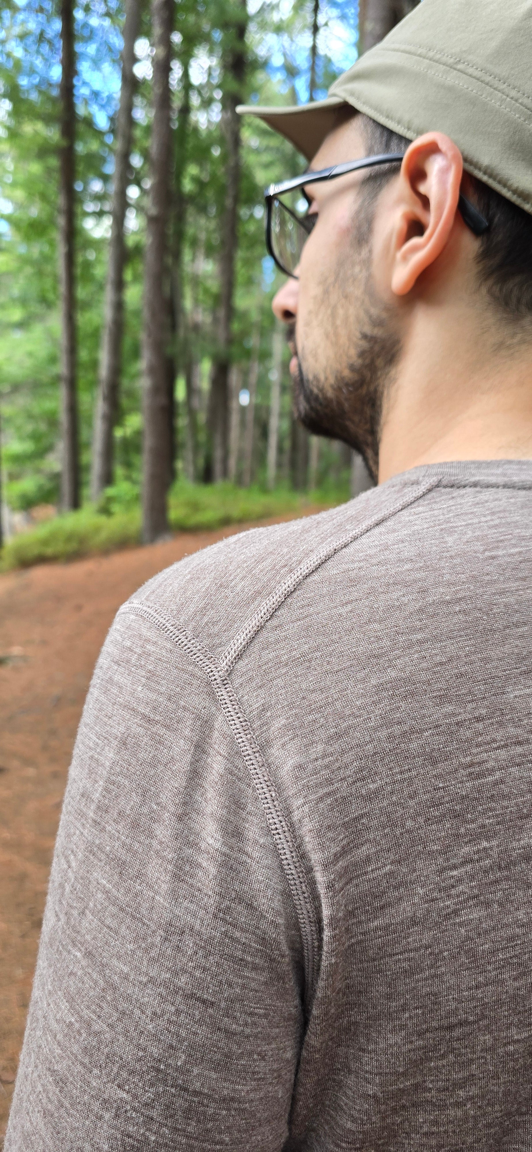 Person wearing a gray shirt showcasing offset shoulder seams in Simsek products